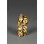 A JAPANESE IVORY FIGURE GROUP NETSUKE of a performer taunting a boy with a mask, signed Masakazu,