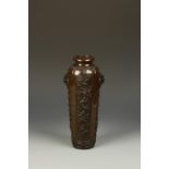 AN ORNATE SLENDER BRONZE VASE of gently tapering form with upper mask handles, the body with four