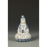 A CHINESE BLUE AND WHITE SMALL GUANYIN FIGURE, the deity seated on a lotus base, probably Qing, 5"