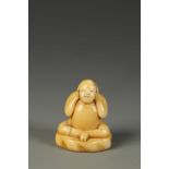 A JAPANESE IVORY FIGURAL TOBORI NETSUKE, the plump Chinese style boy clasping his hands over his