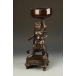 A JAPANESE LARGE BRONZE FIGURE OF A TEMPLE GUARDIAN with a ferocious expression and holding a bowl