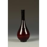 A CHINESE RED-OVERLAID GLASS BOTTLE VASE of slender form, with a rounded lower body, late Qing/