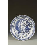 A CHINESE BLUE AND WHITE 'DRAGON AND PHOENIX' CHARGER, the centre with a dragon and phoenix either