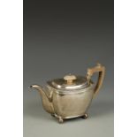 A VICTORIAN TEAPOT of tapering oval form with beaded border and wooden angular handle, on ball feet,