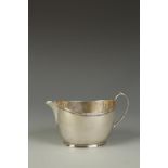 A GEORGE V CREAM JUG of straight sided oval form with ribbon tied reeded border and small spout,