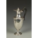AN EDWARDIAN EWER of tapering circular form with a reeded border, scroll handle and flame finial, on