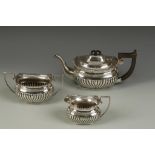 A THREE PIECE TEA SET of oval form with part-fluted decoration and angular handles, by SB & S Ltd,