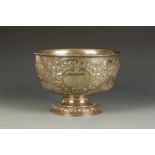 AN EDWARDIAN ROSE BOWL of circular form on a tucked-in circular foot, the body embossed with foliate