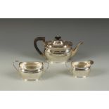 A THREE PIECE TEA SET of oval form with angular handles, monogrammed, by HA, Sheffield 1917, the