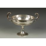 AN EDWARDIAN PRESENTATION PEDESTAL CUP of circular form with scroll handles and central girdle,