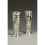 A PAIR OF EDWARDIAN VASES of cylindrical form, embossed with swags and floral garlands with lower