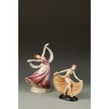 KERAMOS: AN EARTHENWARE MODEL OF A NUDE DANCER, holding her peach skirt aloft, on a black oval base,