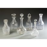 A COLLECTION OF SIX CLEAR GLASS DECANTERS, with cut decoration