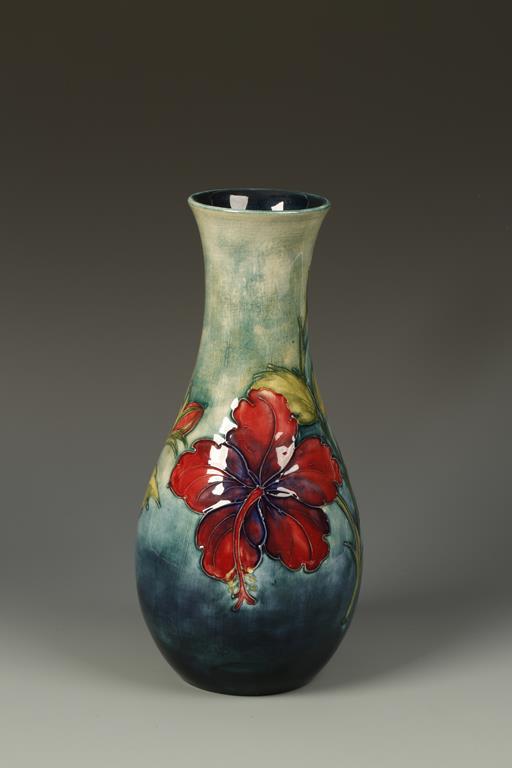 MOORCROFT: A POTTERY VASE decorated with the Hibiscus pattern against a graduated blue ground,