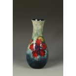 MOORCROFT: A POTTERY VASE decorated with the Hibiscus pattern against a graduated blue ground,