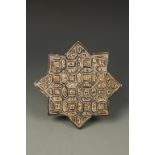 A KASHAN STYLE TILE, of geometric form, decorated in blue and brown pigments, 8" wide