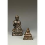 TWO BRONZE SEATED BUDDHAS, the larger Japanese example with one hand raised, 7" high, 19th