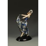 GOLDSCHEIDER: AN EARTHENWARE FIGURE OF A DANCING LADY wearing a hat, painted in blues with