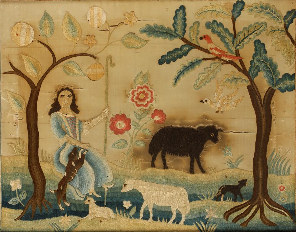 A SILK WORK PICTURE of a shepherdess seated beneath a tree with sheep and animals surrounding her,