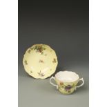 A WORCESTER PORCELAIN CHOCOLATE CUP AND SAUCER with polychrome painted flowers and leaves on a