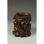 A CHINESE GNARLWOOD BRUSHPOT carved with a deer holding lingzhi, Qing, 17th/18thC, 6" high