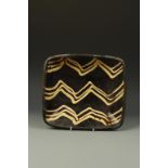 A STAFFORDSHIRE SLIPWARE BAKING DISH, decorated with three lines of three trailed slip zig-zag