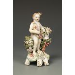 A BOW FIGURE OF A PUTTO, holding a basket of flowers on a flower applied scroll moulded base, c.