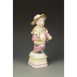 A CONTINENTAL PORCELAIN FIGURE OF A CHINESE MAN, wearing a leaf shaped hat and flower painted robes,