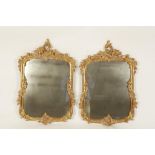 A PAIR OF GEORGE III STYLE GILT FRAMED WALL MIRRORS, with rectangular plates within scrolling gilt