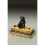 A REGENCY BRONZE AND MARBLE DESK STAND, with a central dog on a stepped base, 11" wide