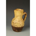 A BARNSTAPLE TYPE SLIPWARE JUG, decorated in light brown with incised floral decoration, 18th