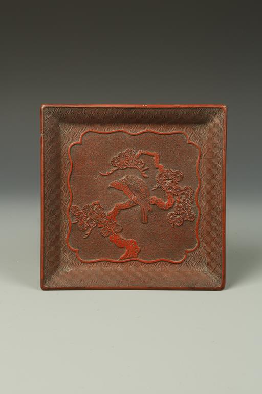 A CHINESE CINNABAR LACQUER SQUARE DISH decorated with a bird on prunus, probably Qing, 7.5" wide