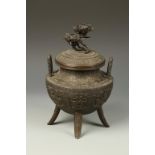 A JAPANESE BRONZE TRIPOD KORO with archaistic relief decoration and a flower finial, signed "