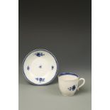 AN ENGLISH BLUE AND WHITE PORCELAIN CUP AND SAUCER with floral spray decoration, 2.5" high