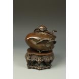 A CHINESE BRONZE PEACH-FORM CENSER, on a pierced hardwood stand, Qing, 18th/19thC, 7.5" long