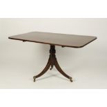 A MAHOGANY TIP-TOP DINING TABLE, the rectangular top on a turned column with three downswept legs,