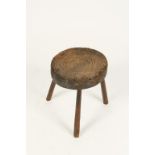 A "COBBLERS" STOOL with circular ringed seat, on splayed legs, probably 18th century, 15" high