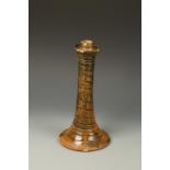 A TREACLE GLAZE POTTERY CANDLE STICK, with incised spiral decoration, 19th century, 12" high