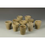 DAVID LEACH: A SET OF TEN POTTERY BEAKERS with a mottled celadon glaze, with impressed initials,