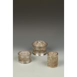 THREE BURMESE SILVER CYLINDRICAL BOXES, with relief decoration, one with a band of figures and