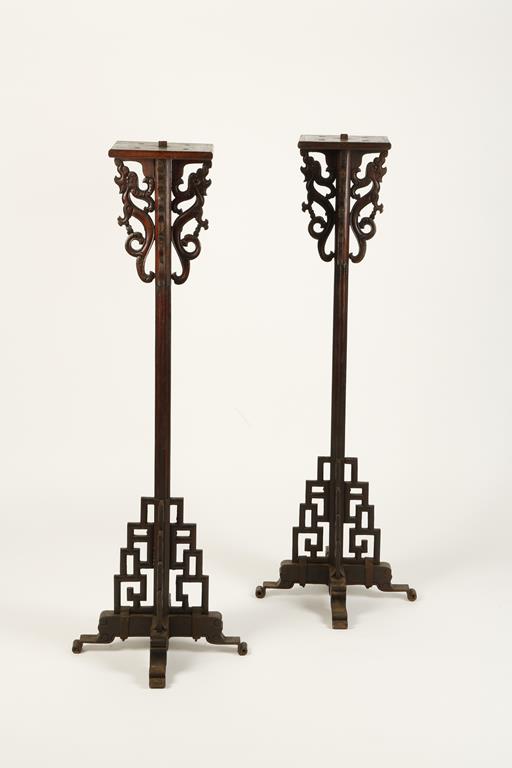 A PAIR OF CHINESE WOOD CANDLESTANDS of geometric form with dragon scroll supports, late Qing/early
