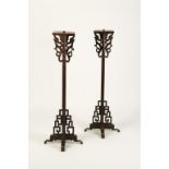 A PAIR OF CHINESE WOOD CANDLESTANDS of geometric form with dragon scroll supports, late Qing/early