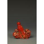 A CHINESE CORAL SNUFF BOTTLE carved with two boys, late Qing/Republic, 3.5" long