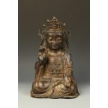 A CHINESE MING-STYLE PARCEL-GILT BRONZE GUANYIN, seated with one hand raised, 16.5" high