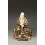A CHINESE CARVED AND PAINTED WOOD FIGURE seated and wearing robes, late Qing/Republic, 12.5" high