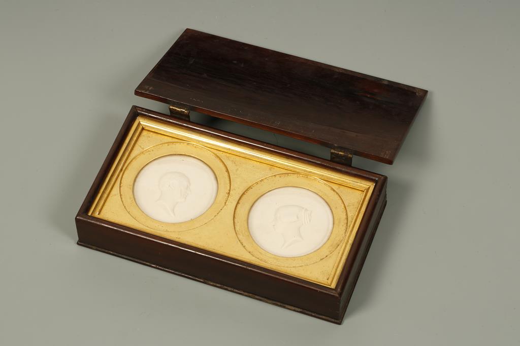 A PAIR OF CASED PARIAN WARE ROUNDELS of Queen Victoria and Prince Albert, in a hinged yew wood