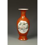 A CHINESE CORAL-GROUND BALUSTER VASE, decorated with landscape roundels, Qianlong mark, late Qing/