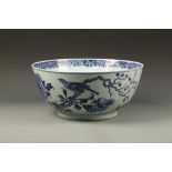 A LARGE CHINESE BLUE AND WHITE BOWL decorated with birds in a garden landscape, Qing, 18th/19thC,