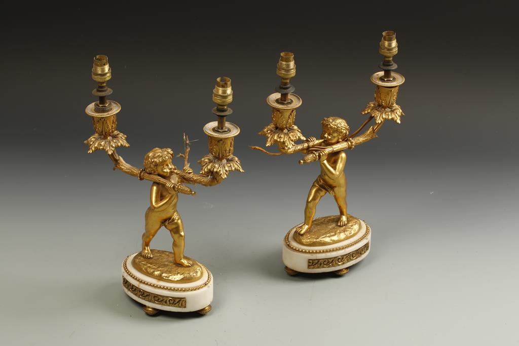 A PAIR OF LOUIS XV STYLE GILT BRONZE LAMPS in the form of cherubs holding the lights aloft, on