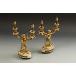 A PAIR OF LOUIS XV STYLE GILT BRONZE LAMPS in the form of cherubs holding the lights aloft, on